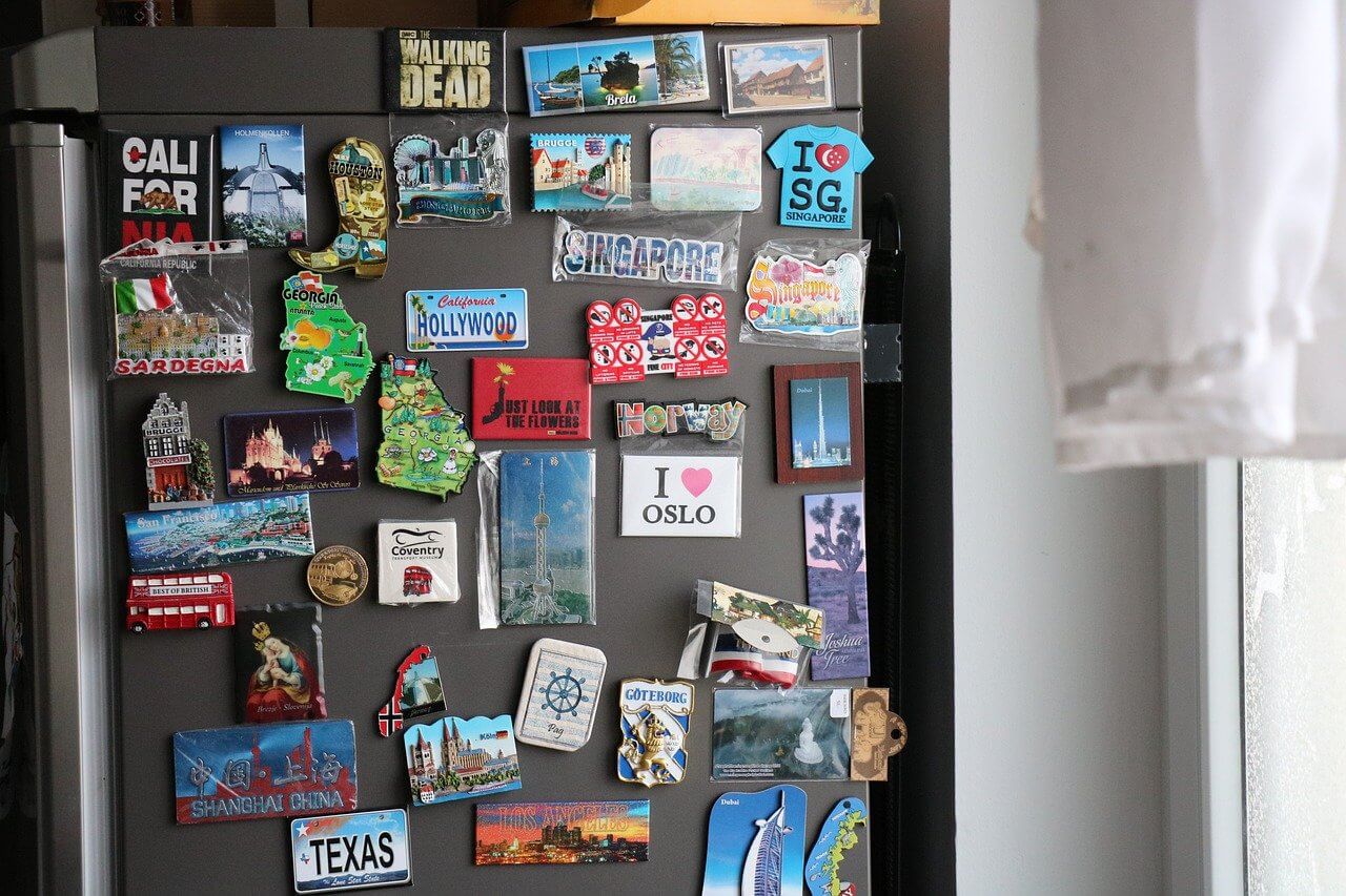 A refrigerator covered in magnets