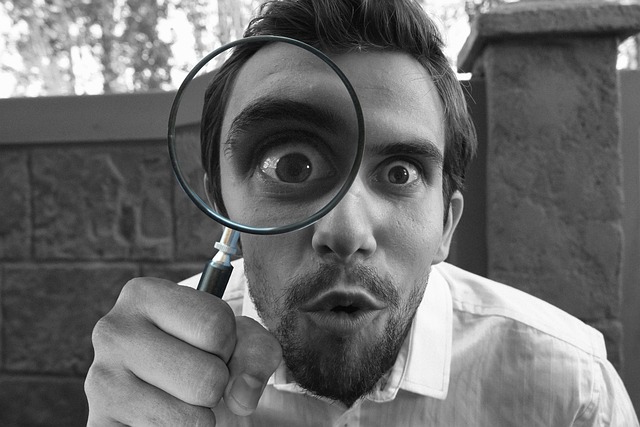 A man with a magnifying glass signifying a detective character written by a self-publishing author